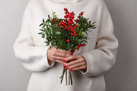 Woman holding Christmas red holly berriesの写真素材