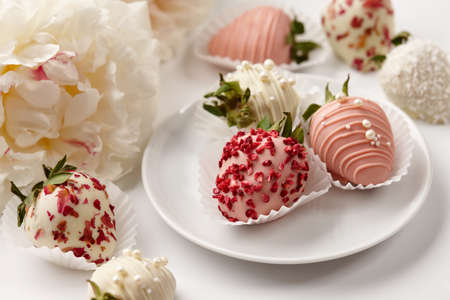 Chocolate dipped strawberries in white plate with peonies