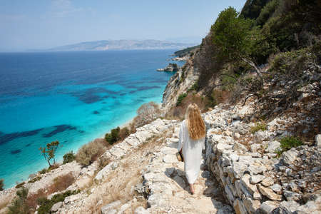 Beautiful woman walking down to the seaの写真素材