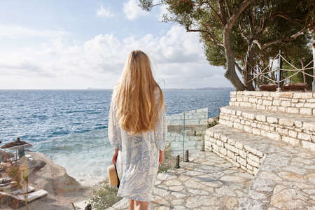 Blonde woman in summer dress at a sea resortの写真素材