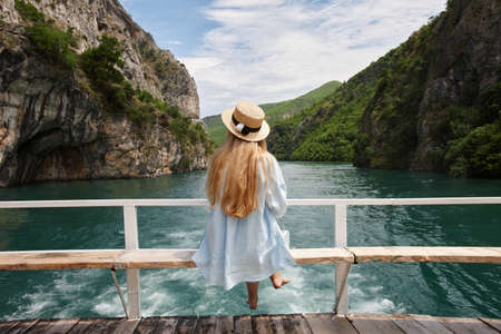 Blonde woman enjoying mountain view on a ferry