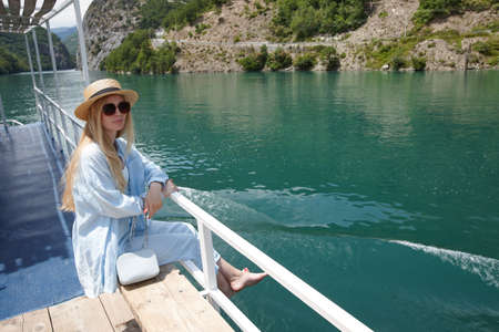 Blonde woman enjoying mountain view on a ferryの写真素材