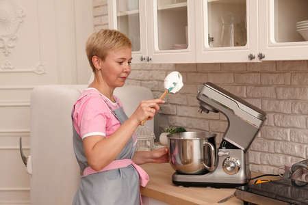Woman confectioner making sweets in the kitchen. Mixing cream for marshmallows.の写真素材