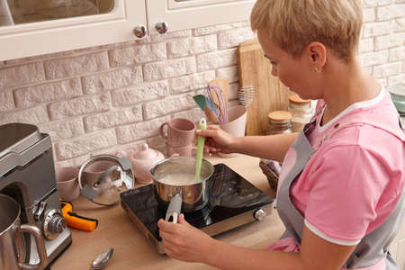 Woman confectioner making sweets in the kitchen. Boiling syrup for marshmallow cream.の写真素材