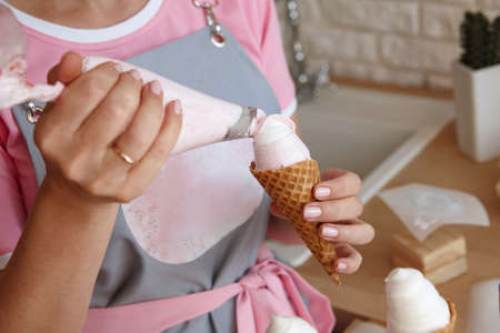 Confectioner making marshmallow ice cream with pastry bag, close up viewの写真素材