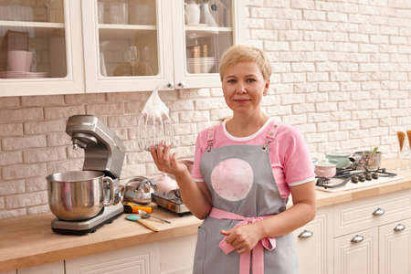 Woman confectioner making sweets in the kitchen. Mixing cream for marshmallows.の写真素材