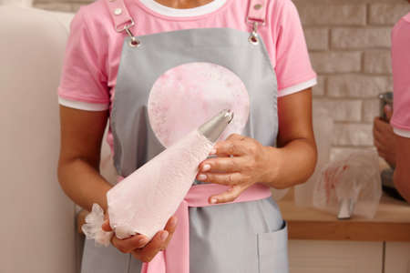 Confectioner in apron with pastry bag, close up viewの写真素材