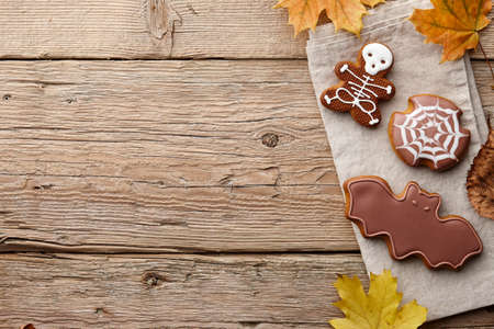 Halloween gingerbread cookies and autumn leaves on wooden planks, copy spaceの写真素材
