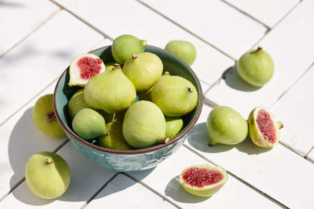 Fresh green figs bowl on white wooden tableの写真素材