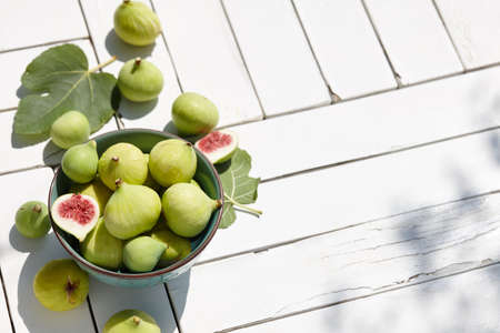Fresh green figs bowl on white wooden tableの写真素材