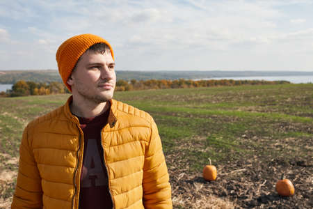 Young mans portrait in pumpkin patch in sunny fall dayの写真素材