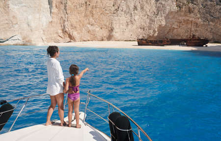 Young mother with daughter enjoying beautiful Navagio beach from yachtの写真素材