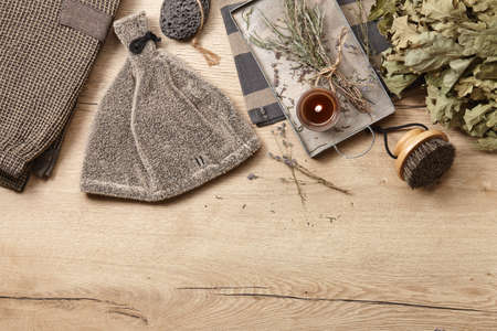 Sauna and spa clothing and accessories on wooden background. Candles and herbs for relaxing and aromatherapy.の写真素材