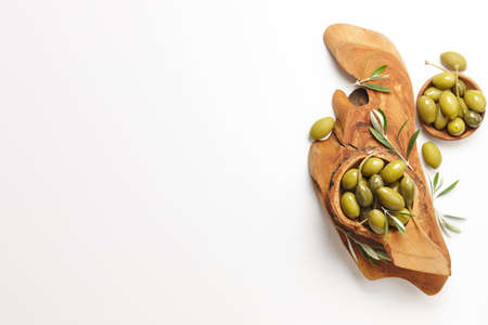 Green olives in wooden bowls on white background, copy spaceの写真素材