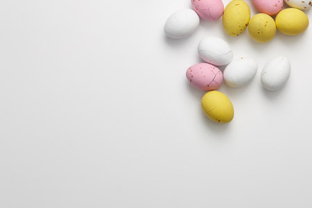 Egg shaped glazed chocolate candies for Easter holiday on white background, copy space