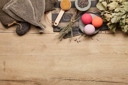 Sauna and spa clothing and accessories on wooden background. Bath bombs and herbs for relaxing and aromatherapy.の写真素材