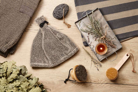 Sauna and spa clothing and accessories on wooden background. Candles and herbs for relaxing and aromatherapy.の写真素材
