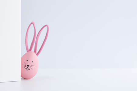 Pink Easter egg with bunny ears. Creative holiday decoration, copy space.の写真素材