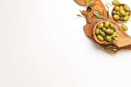 Green olives in wooden bowls on white background, copy spaceの写真素材