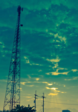 The Communication Antenna Tower and Cloudy Sky with Sunbeam in the Morning.の写真素材