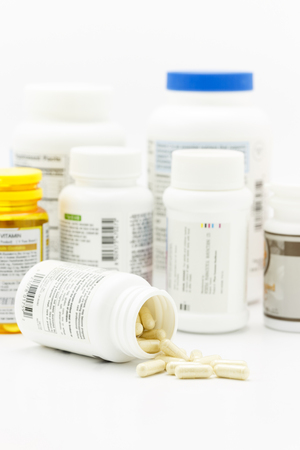 Pills on the white background with medicine bottleの写真素材