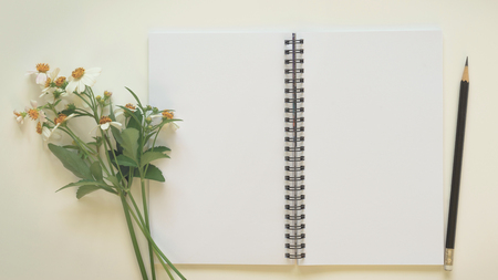 Notepad with pencil and grass flower on the wood backgroundの写真素材