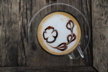 Top view of hot cappuchino offee cup on the old wooden table .の写真素材