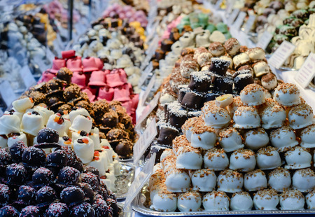 Christmas market in details. A row of colorful sweets, marzipans, desserts.