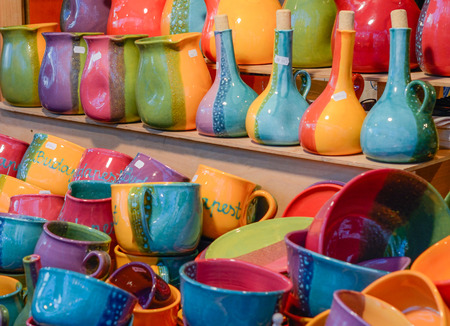 Christmas market in details. Colorful ceramic utensil - cups, bottles and jars.