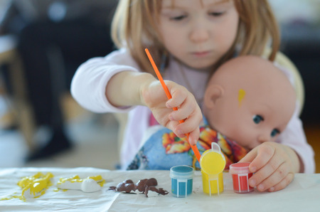 Kid painting plaster figures - giraffe, bear, lionの写真素材