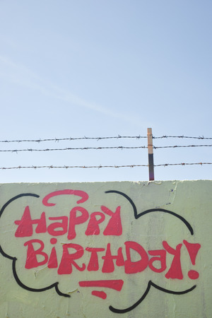 Graffiti art - the wall with barbwire and happy birthdayの写真素材