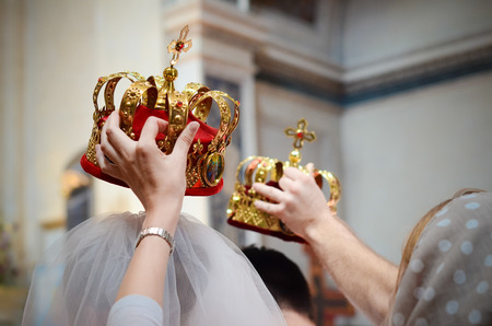 Wedding in Orthodox Church -  witnesses held bridal crowns over the headの写真素材