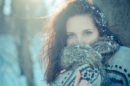 Head-shot of pretty and mysterious brunette girl in snowy forest.の写真素材