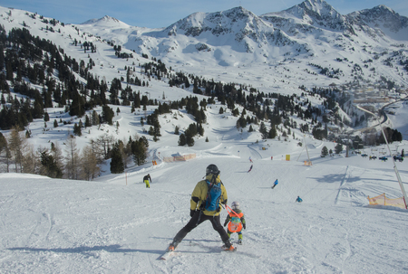 Stunning view of the mountains and skiers family in Obertauern ski resortの写真素材