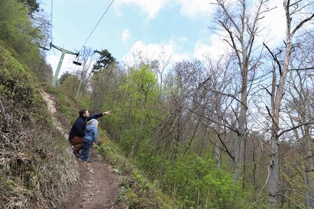 Family walk or hike through the mountain forest in early springの写真素材