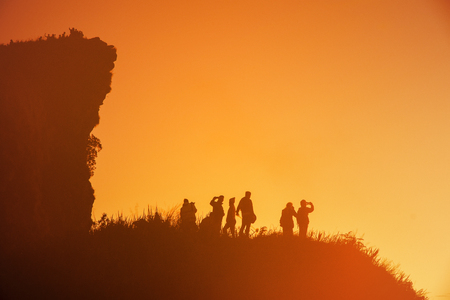 Silhouettes of so many people on top of the hills in the dark awaiting the sunrise.の写真素材