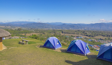 Three tents of blue on the high hills. Background blue sky and  mountain.の写真素材