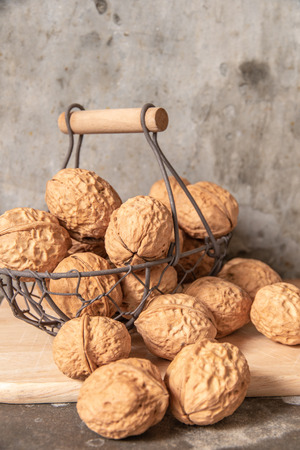walnut in steel basket on the cement table.の写真素材