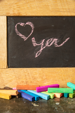 Love you written on blackboard with multi-colored chalk.の写真素材