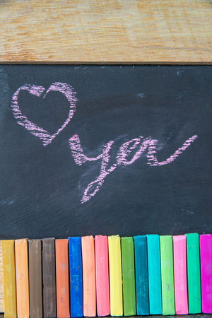 Love you written on blackboard with multi-colored chalk.の写真素材