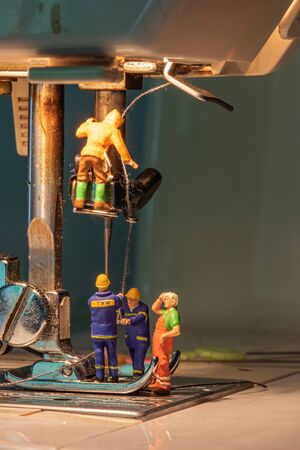 Miniature people change thread on sewing machine.の写真素材