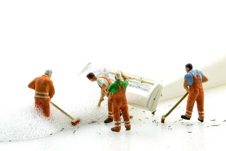 Miniature people cleaning dirty white shaver on white background.の写真素材