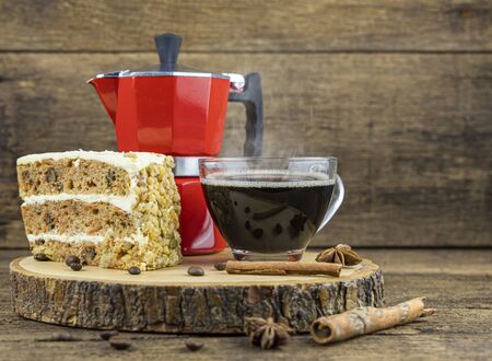 A cup of hot coffee with cake and italian coffee pot(Moka) on wooden table.の写真素材