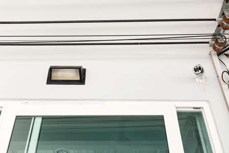 Lamps and CCTV mounted on the front wall of house.