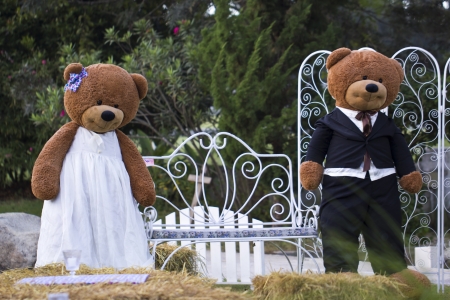 Two big bear dolls stand together in the gardenの写真素材