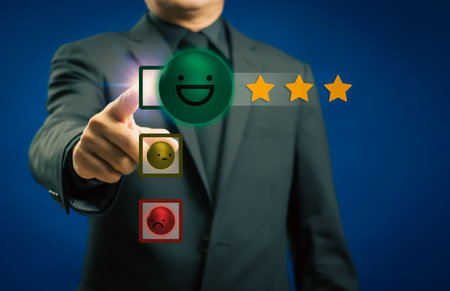 Businessman or customer give rating to service experience on virtual touch screen and finger pressing smiley face emoticon to review satisfaction feedback survey, Customer service evaluation conceptの写真素材