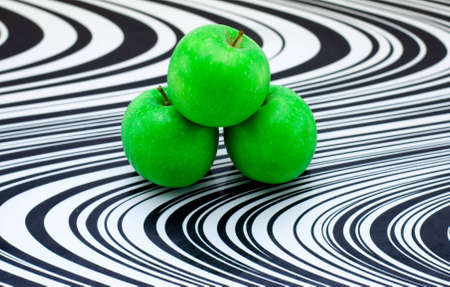 Green apples on black and white glass cutting boardの写真素材