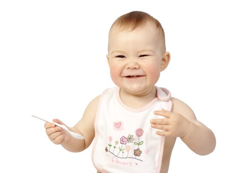Cute child holds spoon and smile, isolated over whiteの写真素材