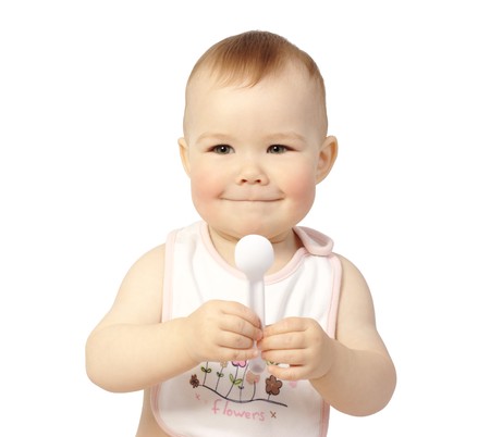 Cute child holds spoon and smile, isolated over whiteの写真素材