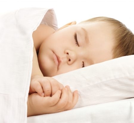 Cute child is sleeping in bed, isolated over whiteの写真素材